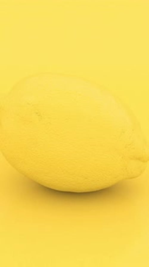 Minimalist Rotating Yellow Lemon on Monochromatic Background