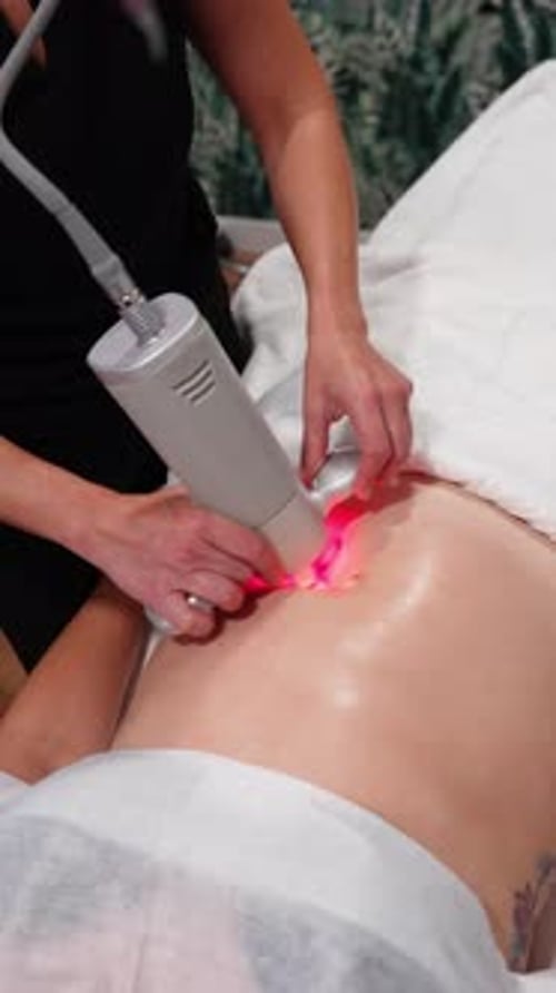Woman getting a red light therapy on abdomen