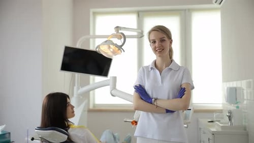 Female Dentist Talking to a Young Patient During Appointment in Modern Dental Clinic Before Teeth