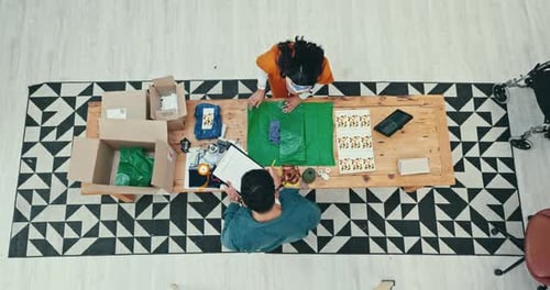 Teamwork, delivery and fashion designer people wrapping a product in office for courier shipping