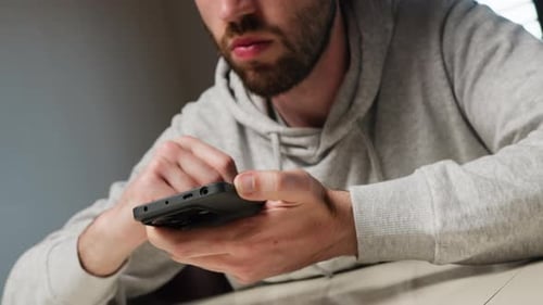 Man Scrolls Bored On The Phone At Home