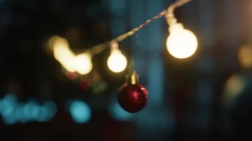 Festive Christmas Ornaments Hanging Near String Lights