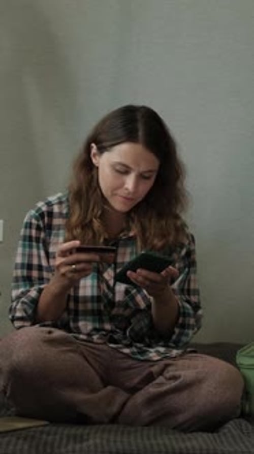 Woman Uses Phone and Credit Card on Blanket