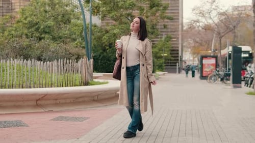 Confident Woman Walks City Sidewalk with Coffee