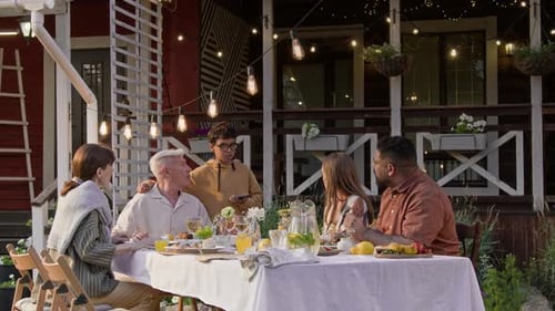 Young Boy Talking to Family at Dinner