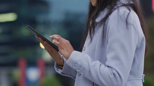 Woman Uses Tablet in City