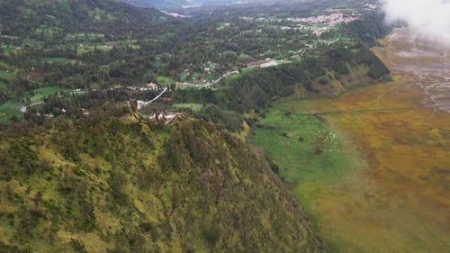 Vue par drone des hautes terres du mont Bromo montrant un terrain boisé, des vallées montagneuses et des terres agricoles disparates