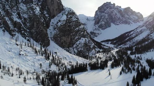 Snowcovered Peaks With Pine Forest Snowy Mountain Scene Featuring Jagged Peaks And Winter Wilderness