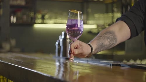Closeup of the Bartender Putting the Finished Cocktail on the Bar and Waiter