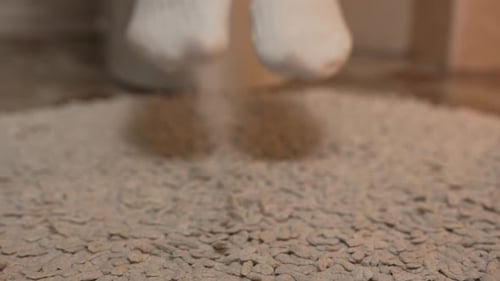 Close-up of a woman's feet in white winter warm socks stepping on a pile mat in the toilet