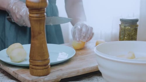 Female's Chef Hands Cut Slices of Potatoes for Frying or Stewing Part of the Process of Cooking on