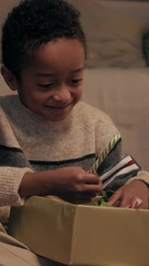 Excited Boy Opens Gift With Candy Cane and Hat