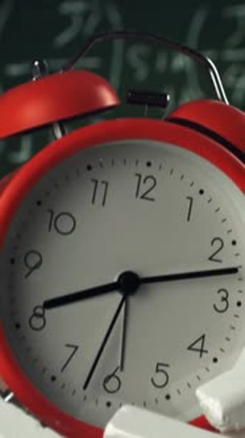 Alarm Clock Flies with School Chalk Against the Background of the Blackboard Filmed on a Highspeed