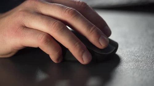 Slow motion close up of a male hand using a wireless computer mouse.