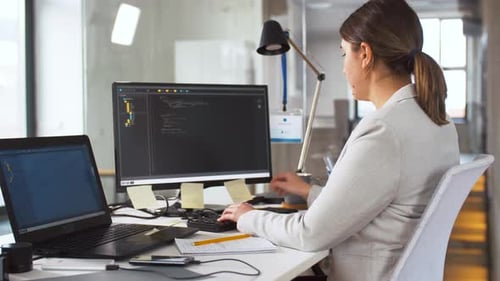 Woman Typing Code at Computer in Modern Office