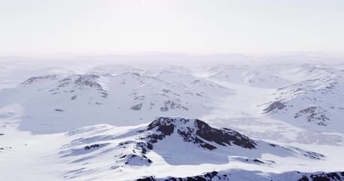 Snowy Mountain Range Under Clear Sky in Winter Landscape During Daylight