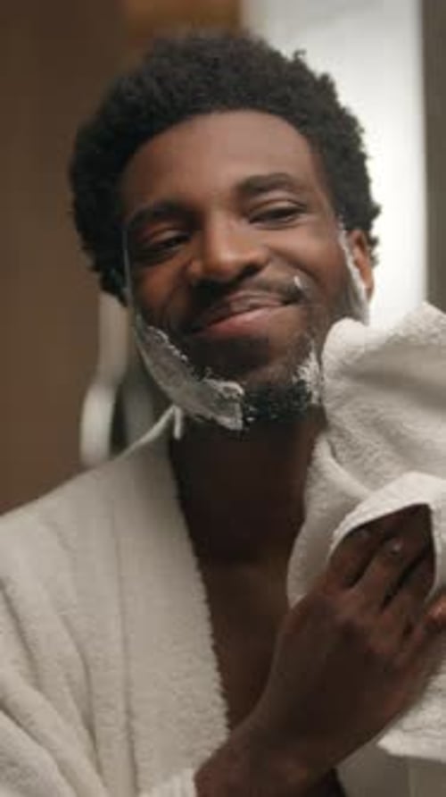 Man Wipes Face with Towel after Shaving