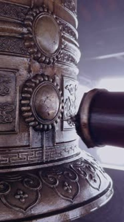 Vertical video. Detailed Ornate Bronze Bell Engraving With Wooden Striker Aligned to Strike Center