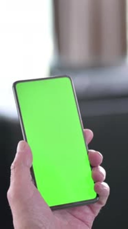 Rear View of Old Man Using Smartphone with Green Chroma Key Screen, vertical video