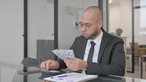 Empresario mestizo haciendo cálculos financieros, contando dinero
