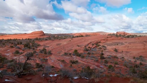 Static Wide shot of a stunning red rock landscape with thick clouds rolling through and a vivid blue