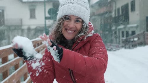 Woman Throws Snowball on Snowy Winter Day