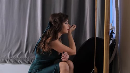 Beautiful Woman Applying Makeup in Front of Mirror