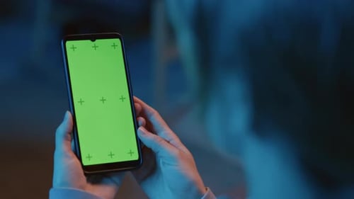 Smartphone in Hands and Green Screen on Display