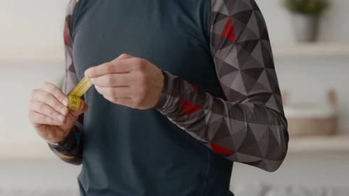Man Holds Measuring Tape Inside His Home