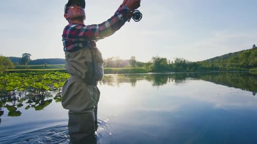 Fly fishing. Man fishing on the river on fly. Male caucasian angler fishing and casting the fly