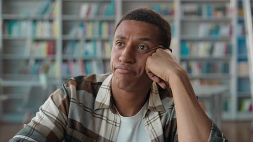 Bored Unhappy African American Man Male Student in Library Tired Guy Looking Away in Boredom Study