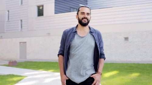 Lifestyle, Leisure and People Concept - Smiling Man Walking Along City Street Active