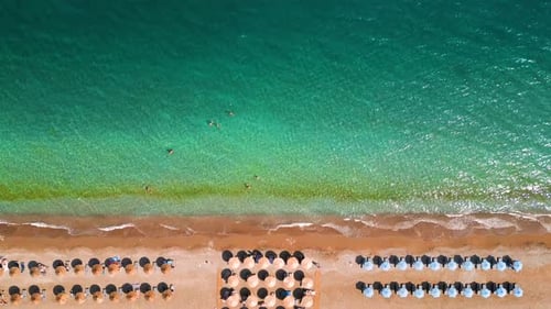 Topdown View of Sandy Beach with Sun Umbrellas and Turquoise Sea Water
