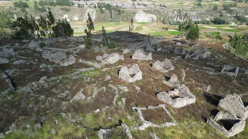 Aerial descends to old stone buildings: Uyo Uyo archeology site, Peru