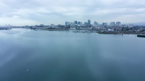 Long view of the city by the bay in the cloudy shipping lanes and overcast skies.