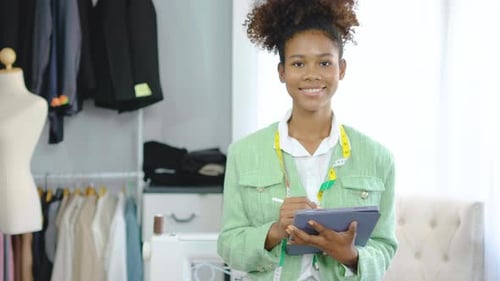 Female Fashion Designer Using Tablet in Studio