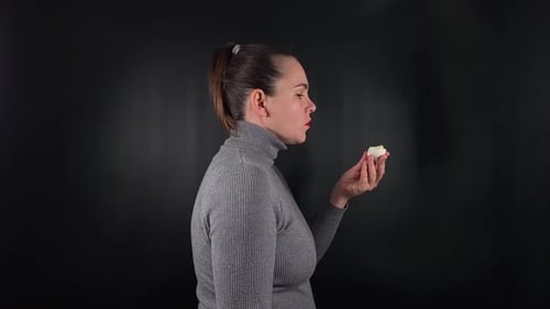 Uma mulher interagindo com um objeto isolado no fundo preto