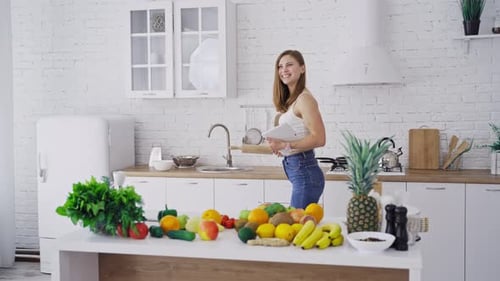 Beautiful woman with the rolling pin in the kitchen.