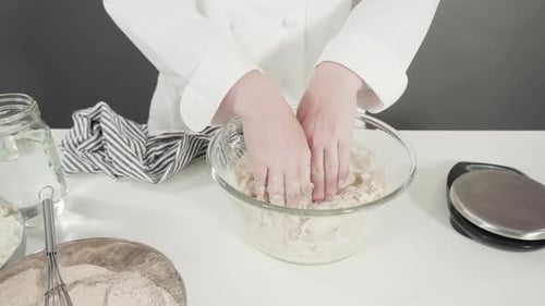 Chef Kneading Dough in Bowl in Bright Kitchen