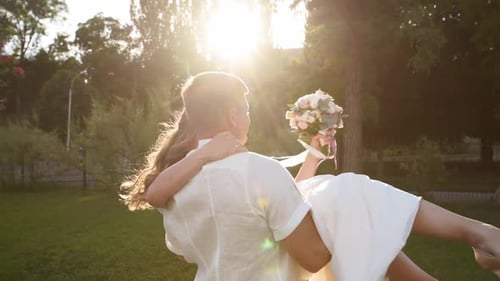 Groom Spins with a Happy Bride on His Hands Newlyweds Couple Have Fun on Warm Summer Evening Wedding