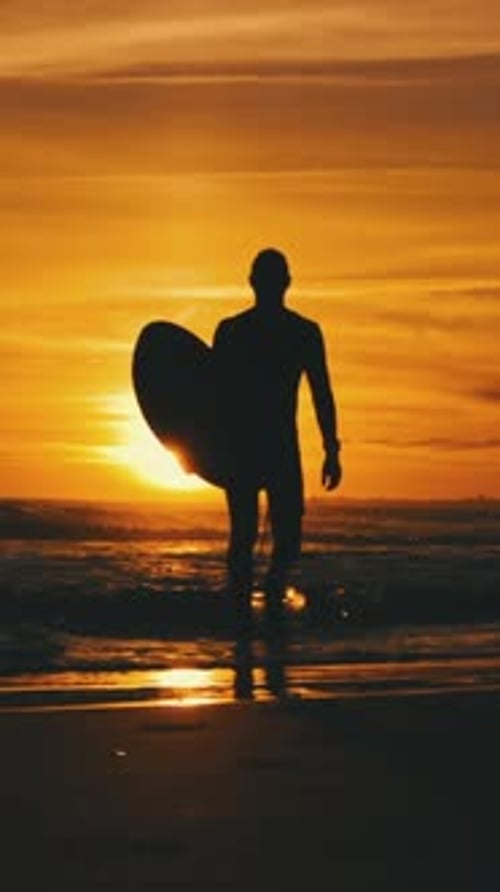 Silhouette of Surfer Walking on Beach at Sunset