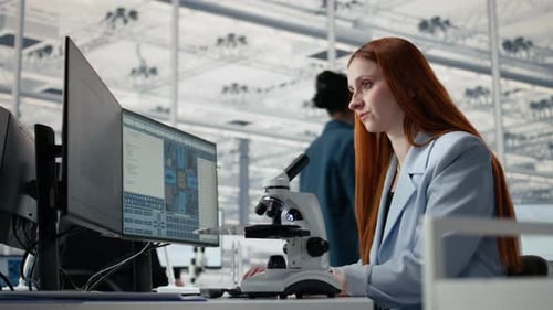 Studying Microchip Architecture Microscope and Woman in Office