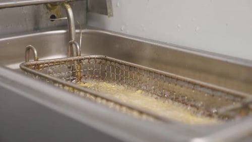 Crispy French Fries is Cooking Into Deep Fryer at Kitchen Delicious Potatoes is Frying in Hot