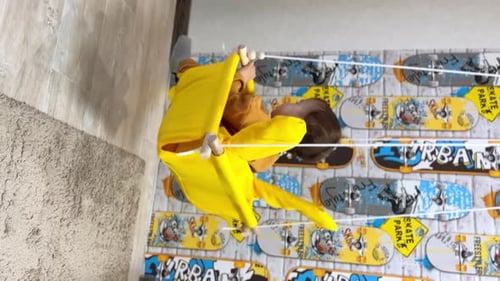 Happy Infant Swinging Indoors in a Yellow Fabric Swing