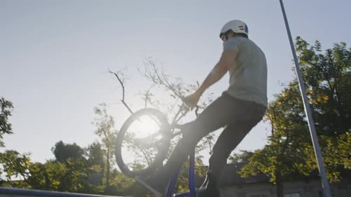 Young Adult Jumps BMX Bike at Skate Park