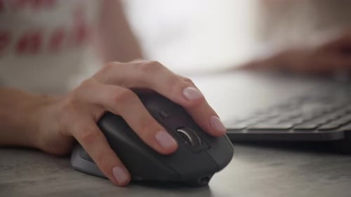 Woman Using a Computer Mouse While Working