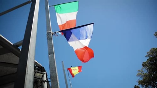 Waving National Flags Against Clear Blue Sky