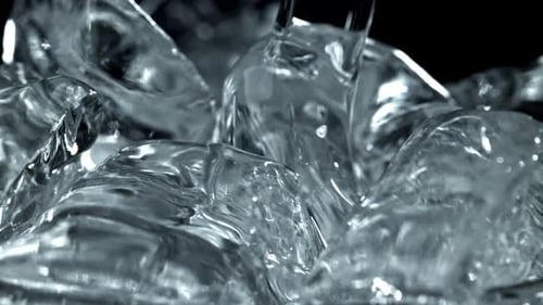 Close up of water pouring over clear ice