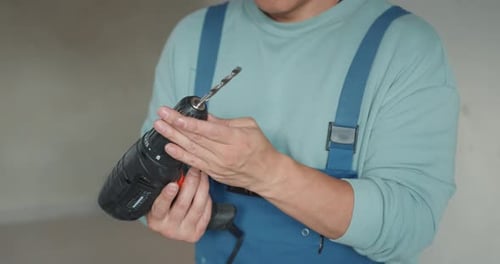 Tradesman Installs Drill Bit in Power Drill