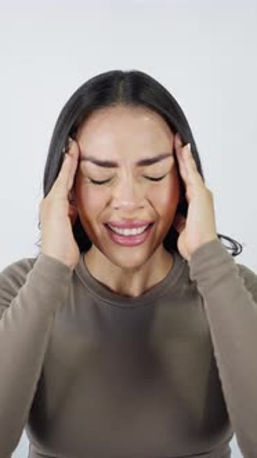Mexican woman experiencing a strong headache isolated on white background